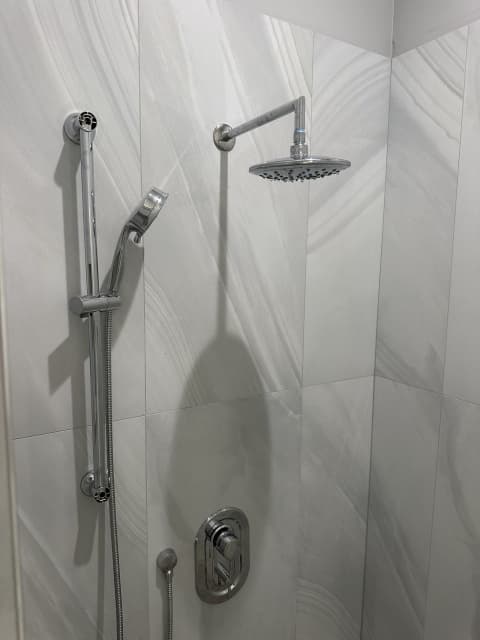 Rain shower and handheld on marble tile