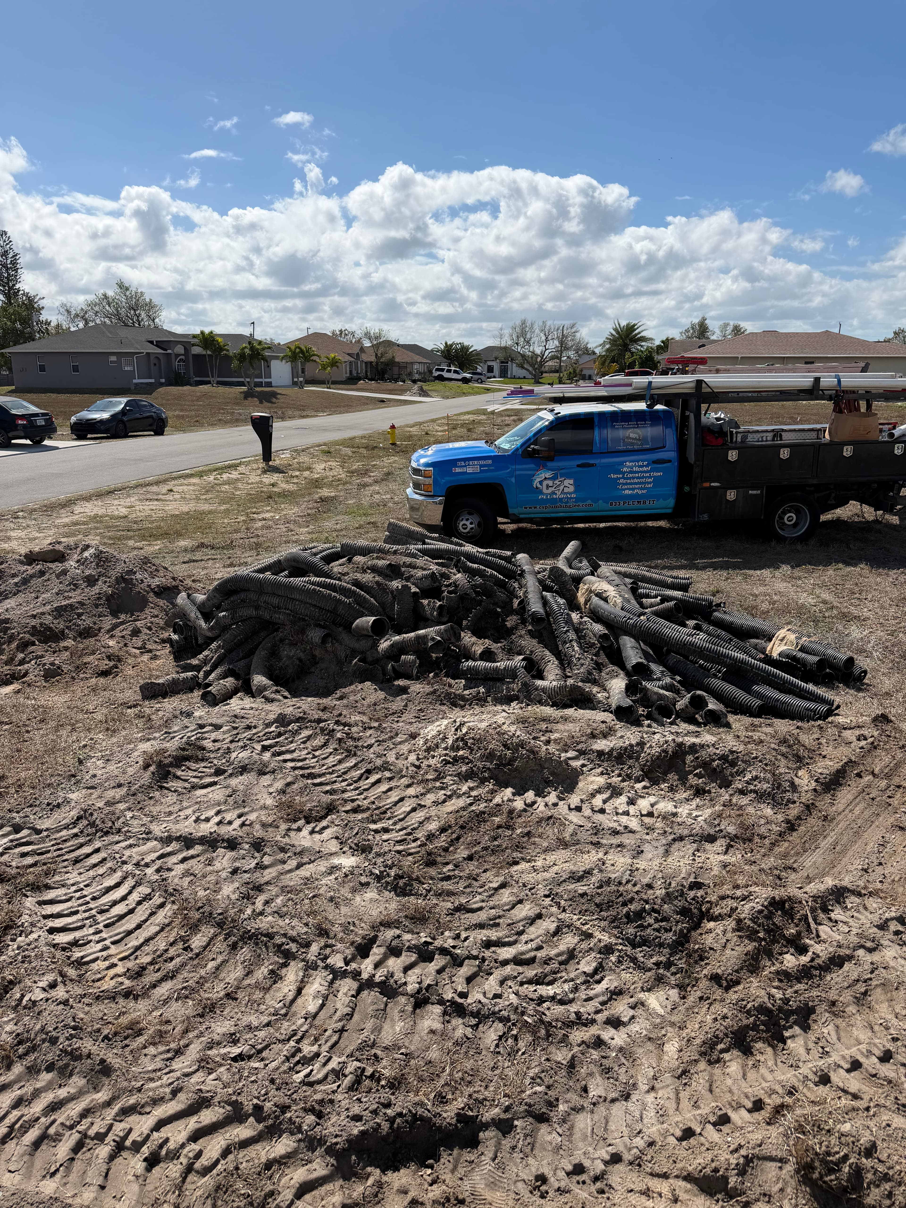 C&S Plumbing truck on site with sewer line excavation and pipe staging for UEP connection
